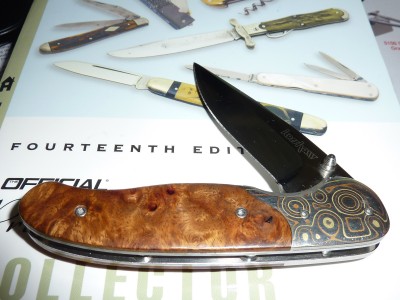 Kershaw Nakamura Quince wood handle and multiple layered metal bolster.