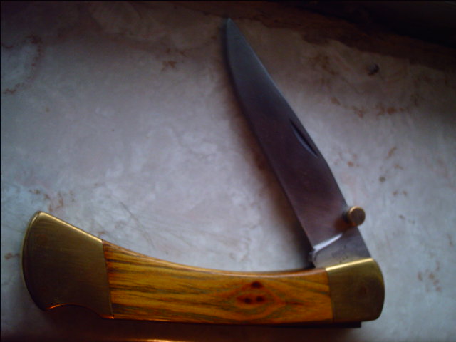 This is a 110 that I reshaped, lengthened the clip, flat ground it, handled in some knotty osage