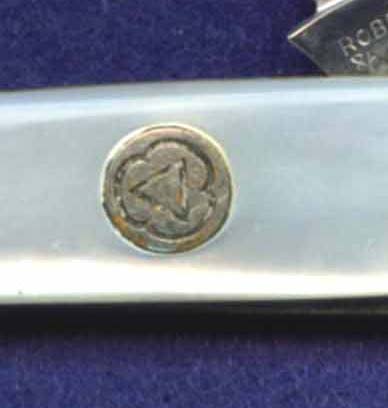 A Cities Service logo shield on a Robeson marked pearl sleeveboard pen knife.