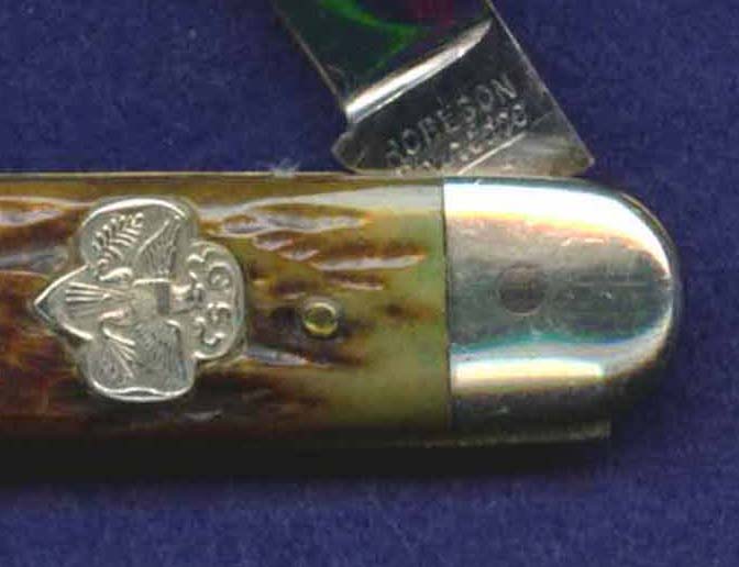 The official Girl Scouts logo shield on a Robeson marked two blade pen knife. Robeson is not known to have ever had a contract to produce official GS knives, yet a few of these are known to exist. The master blade is etched, GIRL * SCOUT with the GS logo between the two words.