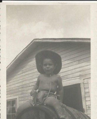 Here I am riding the water barrel with my cowboy hat, late 1940s
