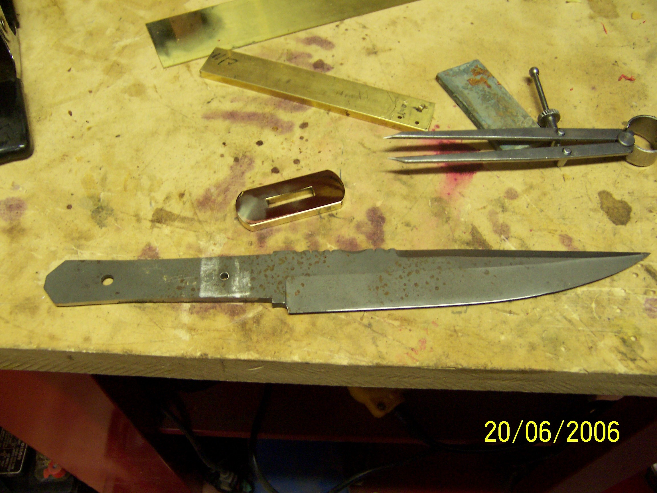 Here is the guard for the coffin handled fighting knife after it was shaped.  It is now ready to be polished.  In the background you can see the bar stock I used to make the guard.