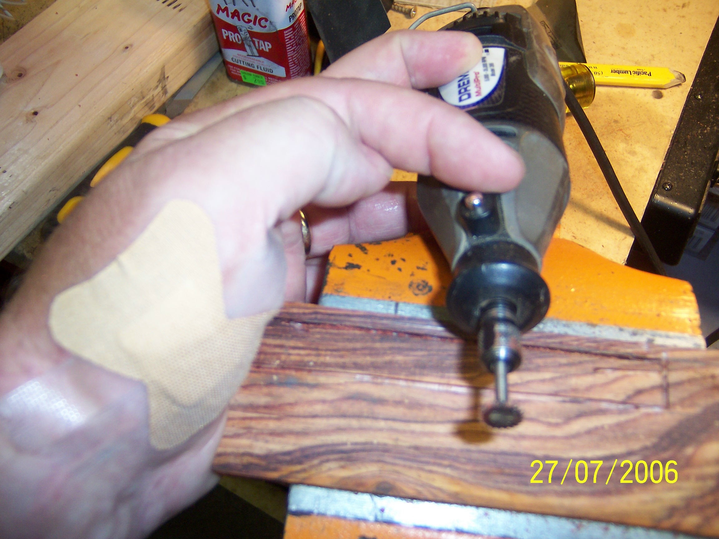 Although I had the blade covered with tape, it was not the only sharp instrument I was working with.  As you can see, clumsy me, I managed to bury the Dremel bit at the base of my left thumb.  Ouch!