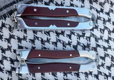 On top is a 1950s production knife, and below is a circa 1949 example. The top example has plastic scales with a W shape cut into them, while the bottom has full width celluloid scales. I think that handles are different materials too, I suspect that the later top example has stainless steel handles, while the earlier bottom example is aluminum.