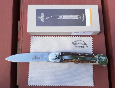The Otter-made version comes with this cloth and a box with an Otter branded info card. The lever is solid, without a hole in it, unlike the old ones.