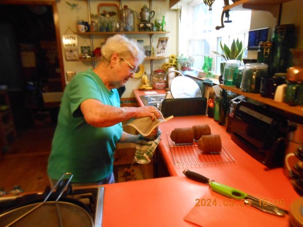 Miss Joy carefully removing the pumpkin bread roll from the coffee can.