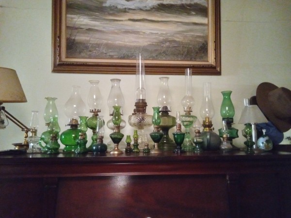 Living room south wall on top of piano, oil lamps.