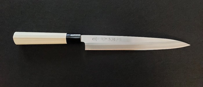 Right handed - with the edge bevel on the right side of the blade