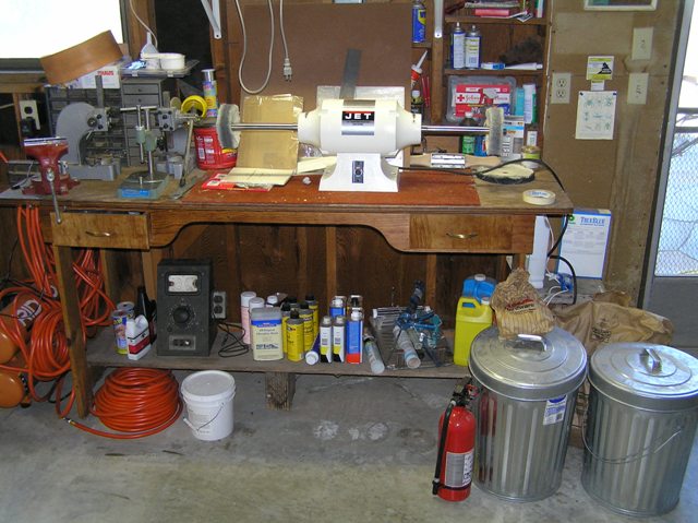 Big Buffer and assorted chemicals under the bench. There are a couple arbor presses and some storage drawers. I keep 2 charged fire extinguishers in the shop.